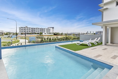 Outdoor pool, open 7:00 AM to 9:00 PM, pool loungers. Aquarius Kawana