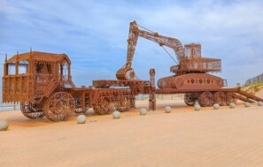 Une grande sculpture métallique complexe, qui ressemble à un engin de chantier.