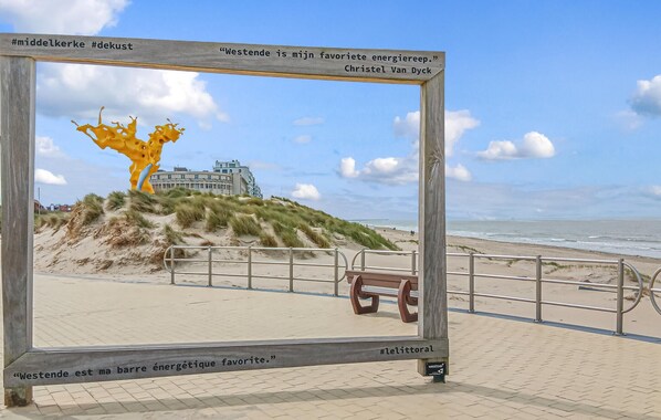 Une vue sur la plage, avec une structure en bois encadrant un texte et une citation.