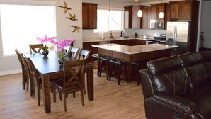 Une cuisine moderne avec des meubles en bois, un îlot central et des tabourets de bar.