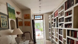 A library with bookshelves, a reading table, and a window. - Provençal farmhouse in the countryside, with air conditioning and a pool, near Avignon (Monteux)
