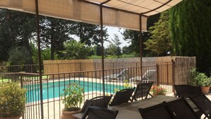 A covered patio area with a pool, outdoor furniture, and potted plants. - Provençal farmhouse in the countryside, with air conditioning and a pool, near Avignon (Monteux)