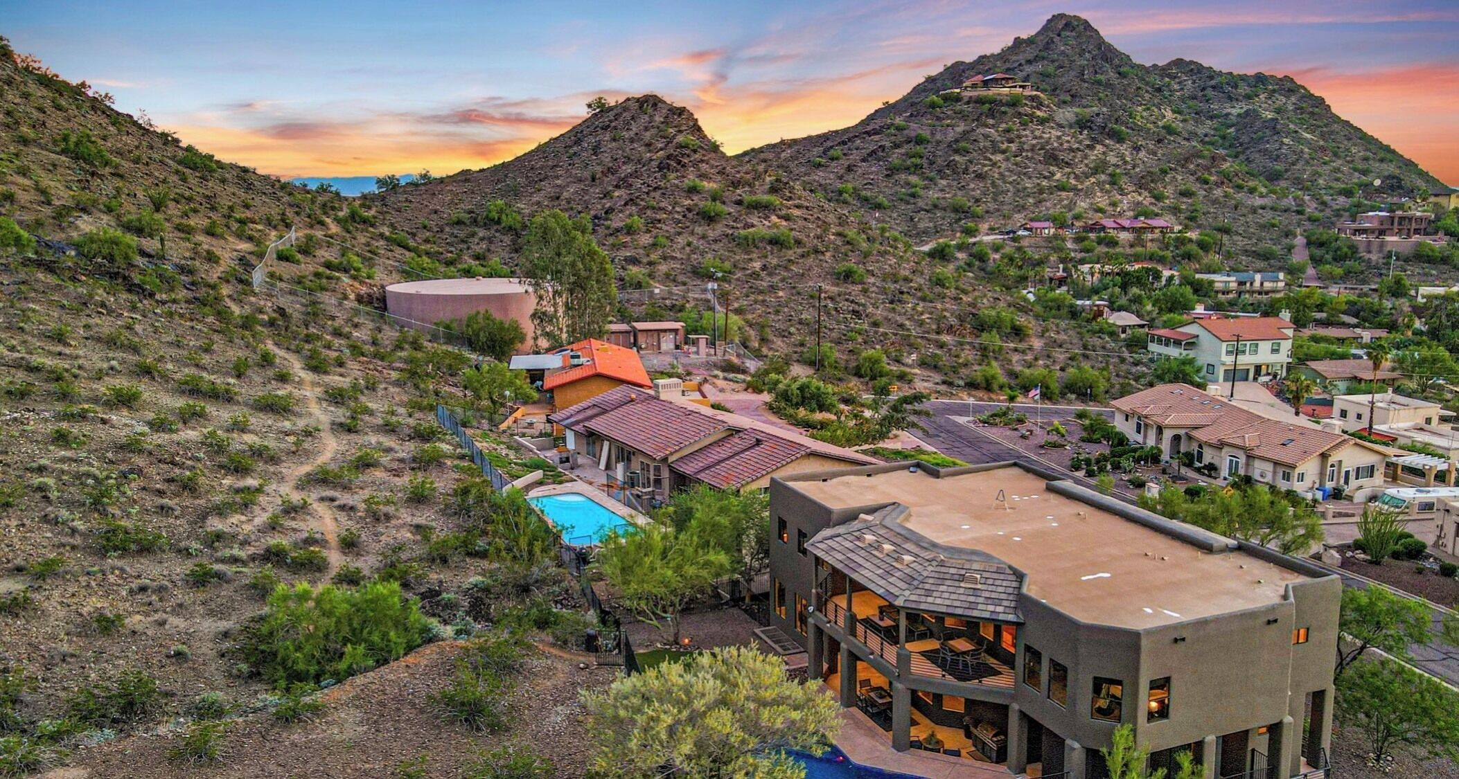 A resort with a pool, multiple buildings, and a mountainous backdrop.