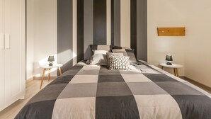 A bedroom with a large bed, two bedside tables, a wardrobe, and a wooden headboard. - Independent house facing the sea with balcony and terrace (Saint-Vaast-la-Hougue)