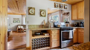 A kitchen with wooden cabinets, a stove, and a wine rack.