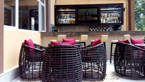 A bar area with wicker chairs and a tiled floor. - Elysian Resort (Nairobi)