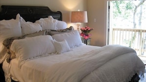Una cama bien hecha con ropa blanca y un cabecero oscuro.