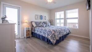 Un dormitorio con cama, mesita de noche, cómoda y ventilador de techo.