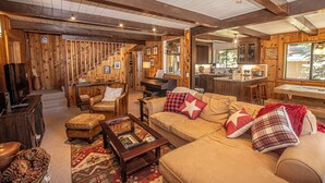 A cozy cabin interior with a living room, kitchen, and dining area. - Edelweiss Escape by Hauserman Rental Group (Tahoe City)