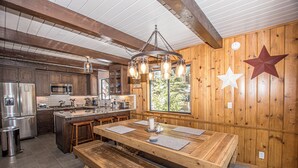 A spacious kitchen with wooden cabinetry, a large island, and modern appliances. - Edelweiss Escape by Hauserman Rental Group (Tahoe City)