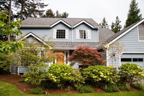 Set amidst a serene garden, this charming home features a central entrance and a beautifully maintained outdoor space.
