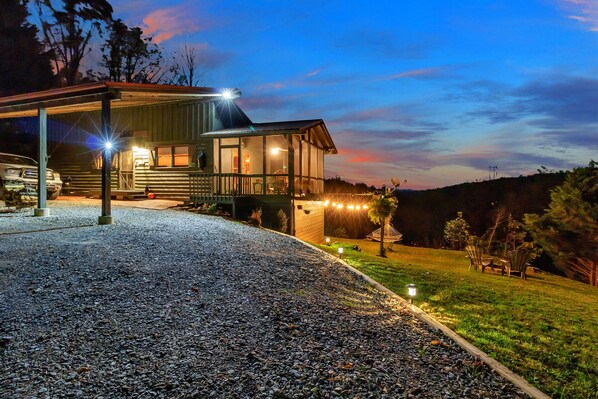 Guest house with a covered porch, garage, and lawn seating area.