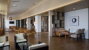 A spacious lobby with a modern design, featuring a mix of seating areas and a large bookshelf. - Prolit Lanke Hotel (Chengdu)