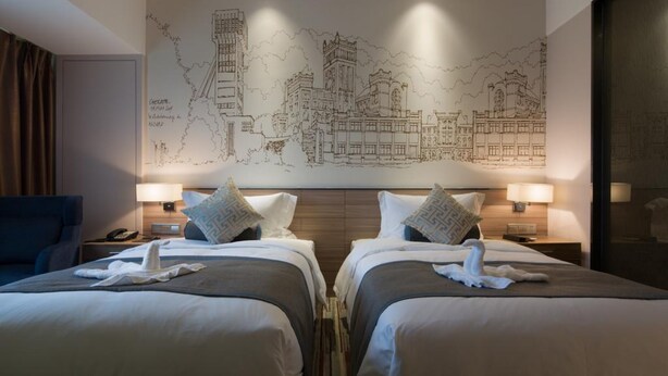 A hotel room with two beds, a large wall map, and a cityscape view. - Prolit Lanke Hotel (Chengdu)