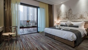 A hotel room with a large bed, a balcony with a table and chairs, and a cityscape view. - Prolit Lanke Hotel (Chengdu)