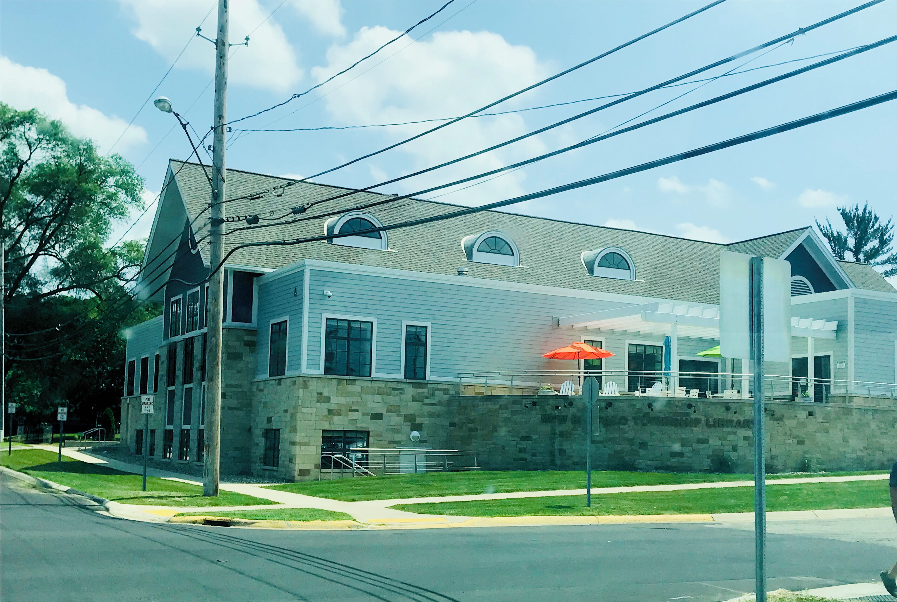 A two-story building with a stone facade, large windows, and a flat roof.