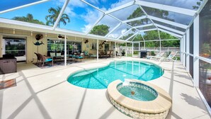 Ein überdachter Poolbereich im Freien mit Whirlpool, Liegestühlen und einer Terrasse mit Tischen und Stühlen.