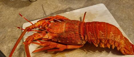 A lobster on a wooden cutting board.