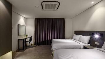 A hotel room with two beds, a desk, a chair, a mirror, and a large window with curtains.