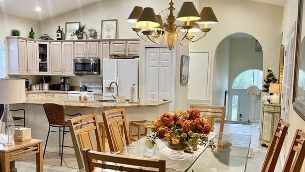 A spacious kitchen with a central island, wooden chairs, and a glass dining table set for six. - 400 yards to Siesta Key Village, 800 yard To The public Beach Access 2 and 7. (Siesta Key)