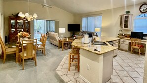 A spacious living area with a dining table, chairs, a kitchen island, and a television. - 400 yards to Siesta Key Village, 800 yard To The public Beach Access 2 and 7. (Siesta Key)
