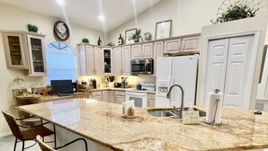 A spacious kitchen with a large island, bar stools, and modern appliances. - 400 yards to Siesta Key Village, 800 yard To The public Beach Access 2 and 7. (Siesta Key)