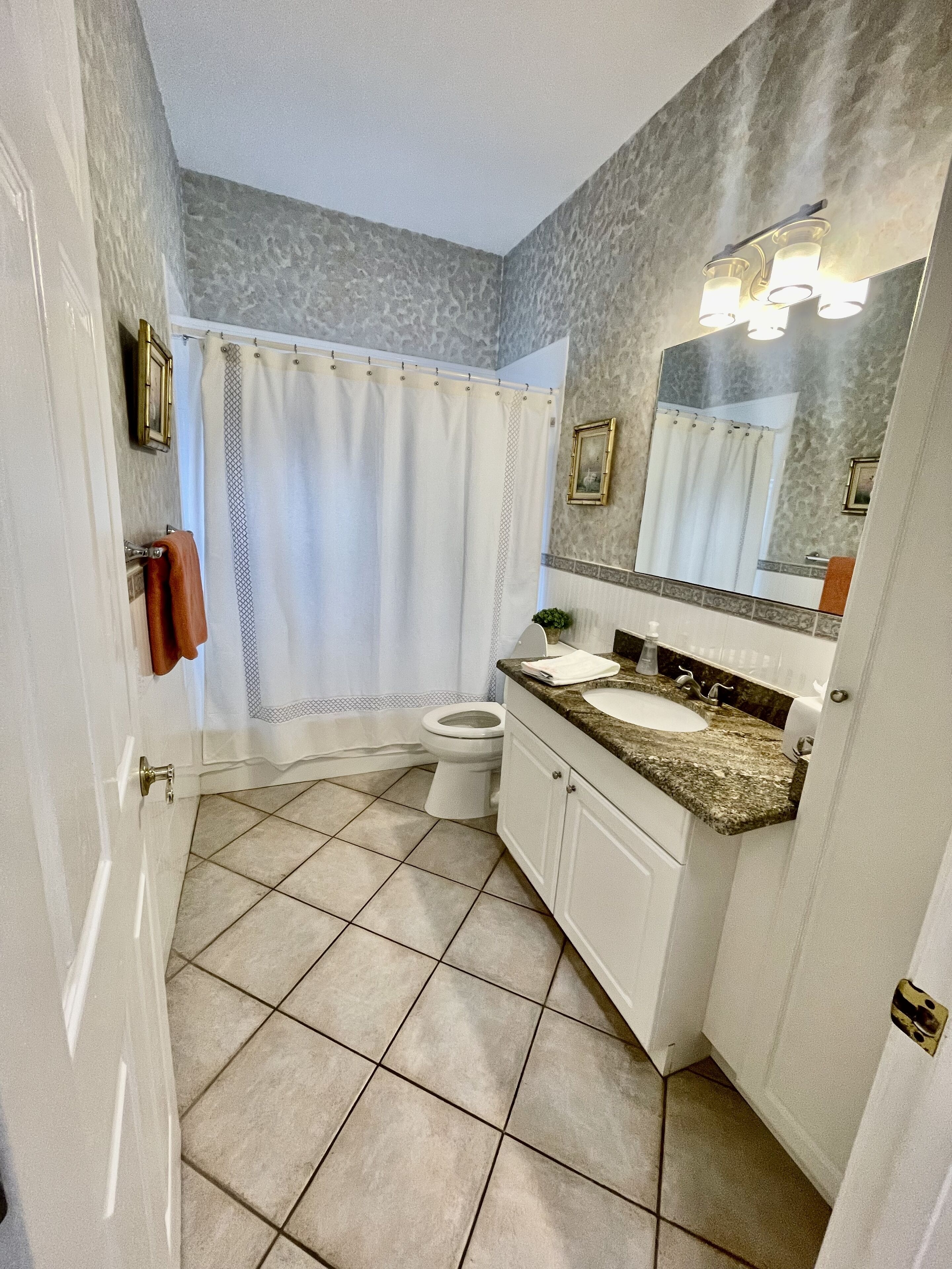 A bathroom with a toilet, sink, and shower curtain.