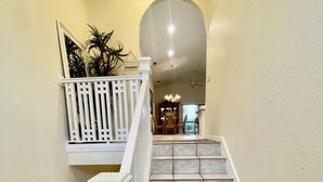 A staircase with white railings and beige tiles, leading to a landing with a view of a dining area. - 400 yards to Siesta Key Village, 800 yard To The public Beach Access 2 and 7. (Siesta Key)