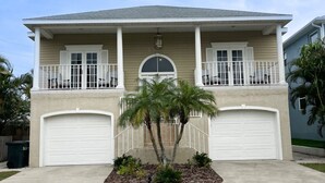 A two-story house with a front porch, two garage doors, and a small palm tree in the front yard. - 400 yards to Siesta Key Village, 800 yard To The public Beach Access 2 and 7. (Siesta Key)