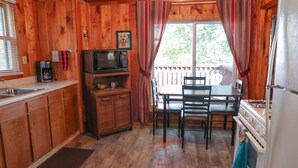 A wooden cabin interior with a kitchen, dining table, and chairs. - Lakeview cabin on stunning Lake Vermilion (Tower)
