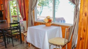 A room with a table and chairs, a window with curtains, and a view of the outside. - Lakeview cabin on stunning Lake Vermilion (Tower)