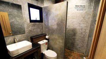 Un baño con lavamanos, inodoro y ducha blancos.