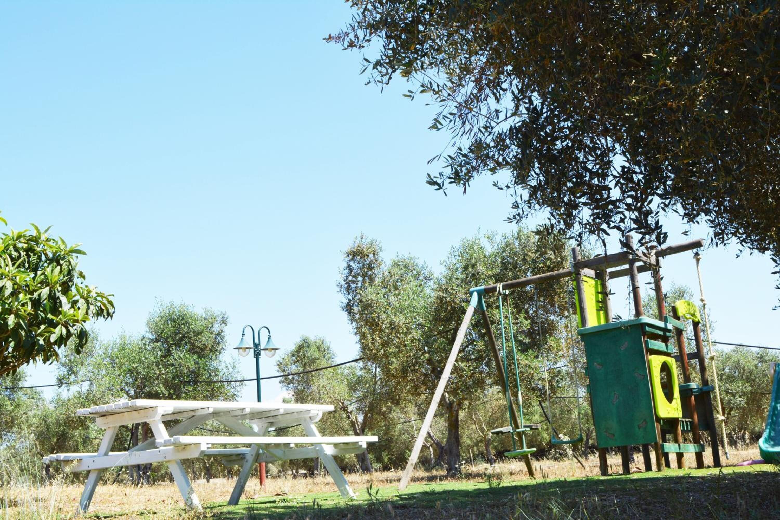 A picnic table and playground equipment in a park.