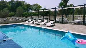 Une piscine équipée de chaises longues et de jeux gonflables.