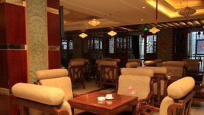 Interior de un restaurante de estilo tradicional con mobiliario de madera, faroles colgantes y ventanas decorativas.