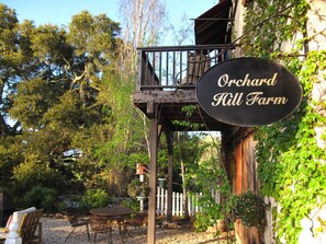 An outdoor seating area with a sign that reads 'Orchard Hill Farm.'