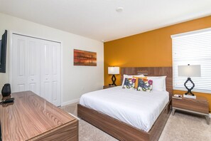 A bedroom with a bed, bedside tables, a desk, and a wardrobe. - Disney near: 9BR Oasis w Pool & Game Room (Davenport)