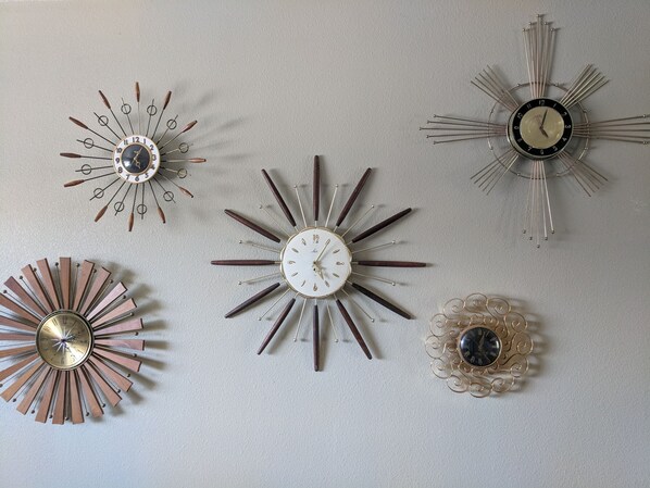 Unique wall decor featuring a collection of five clocks in various styles.