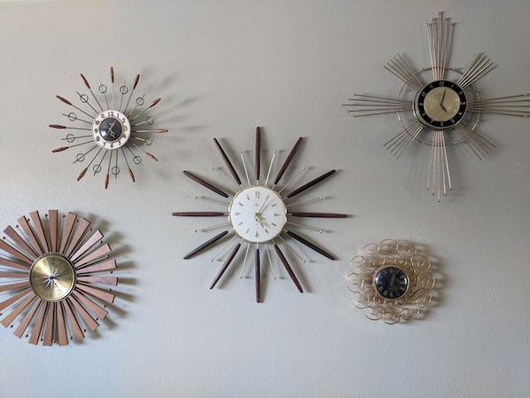 Unique wall decor featuring a collection of five clocks in various styles.