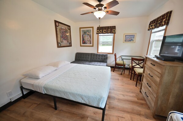 A bedroom with a bed, a desk, a chair, a dresser, and a ceiling fan. - Two Bed Two Bathroom Cabin with kitchenette area (Williams Bay)