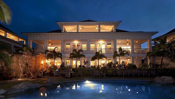 A large, multi-story hotel with a pool in front.