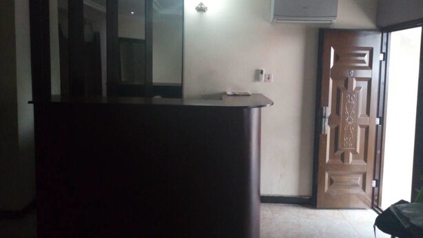 Una habitación con un escritorio de madera oscura, una puerta de diseño elaborado y un aire acondicionado instalado en la pared.