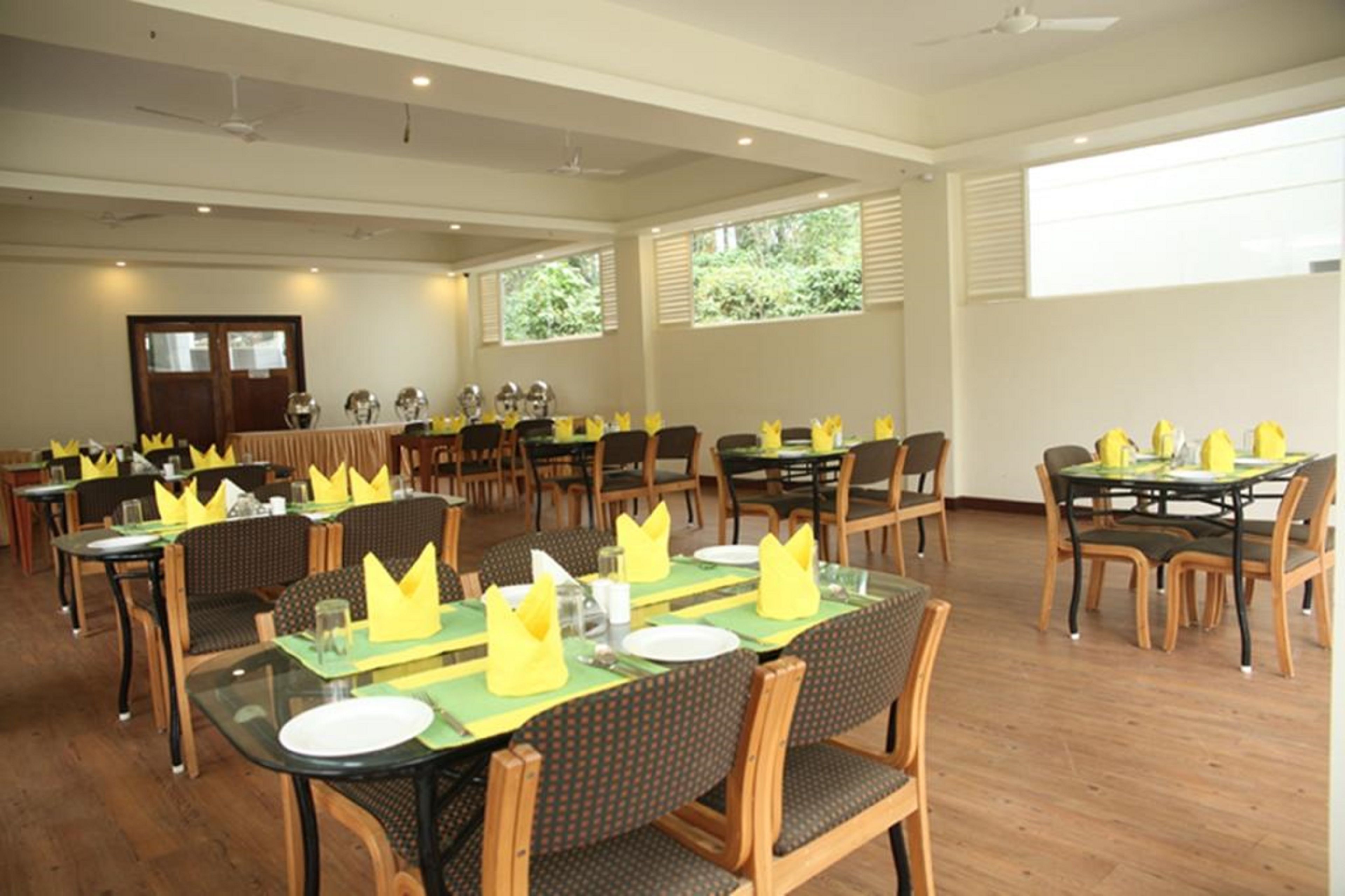 A spacious dining area with multiple tables and chairs, arranged in a banquet style.
