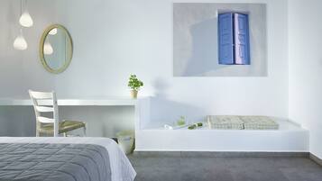 Un dormitorio moderno con cama, escritorio, silla, mesita con planta y estante en la pared con cojín y adornos.