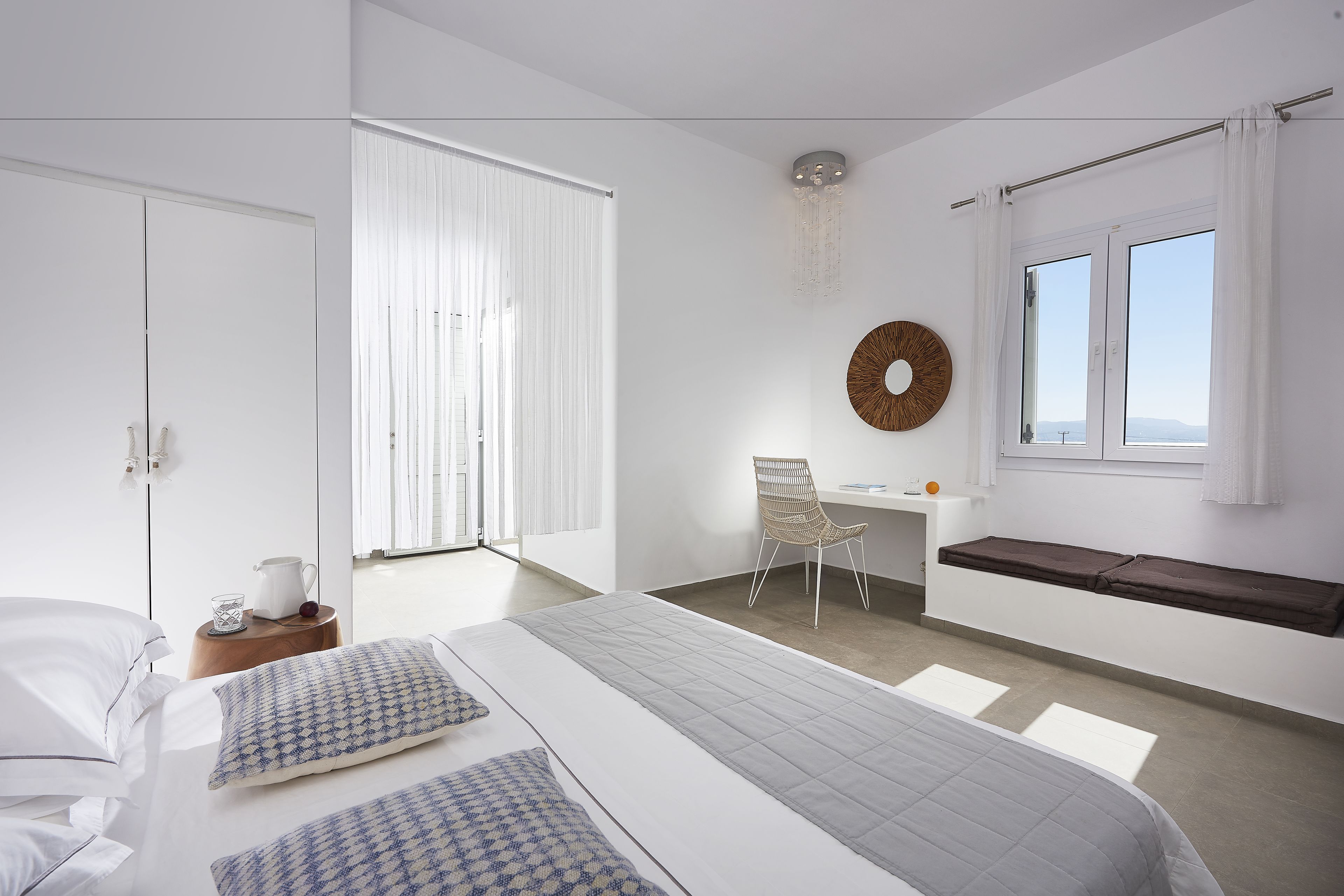 Een moderne slaapkamer met een groot bed, een bureau en een raam met gordijnen.