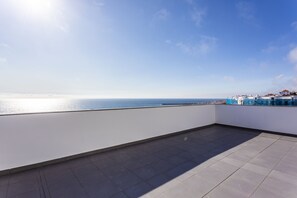 A rooftop terrace with a clear view of the sea and distant buildings. - You and the sea (Mafra)