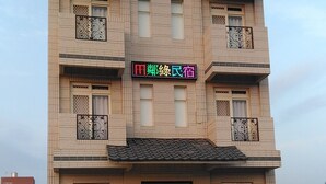 Un immeuble à plusieurs étages, doté d’une façade carrelée, d’une porte noire et d’une enseigne avec des caractères chinois.