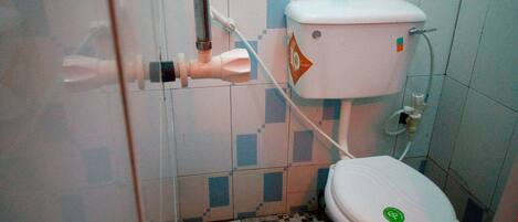 A small bathroom with a toilet, a hand dryer, and a tiled floor.