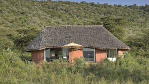 A thatched-roof building with large windows and a patio area. - Spirit Of The Masai Mara (Maasai Mara)