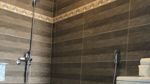 Ein Badezimmer mit Dusche, Toilette und Fliesenboden.
